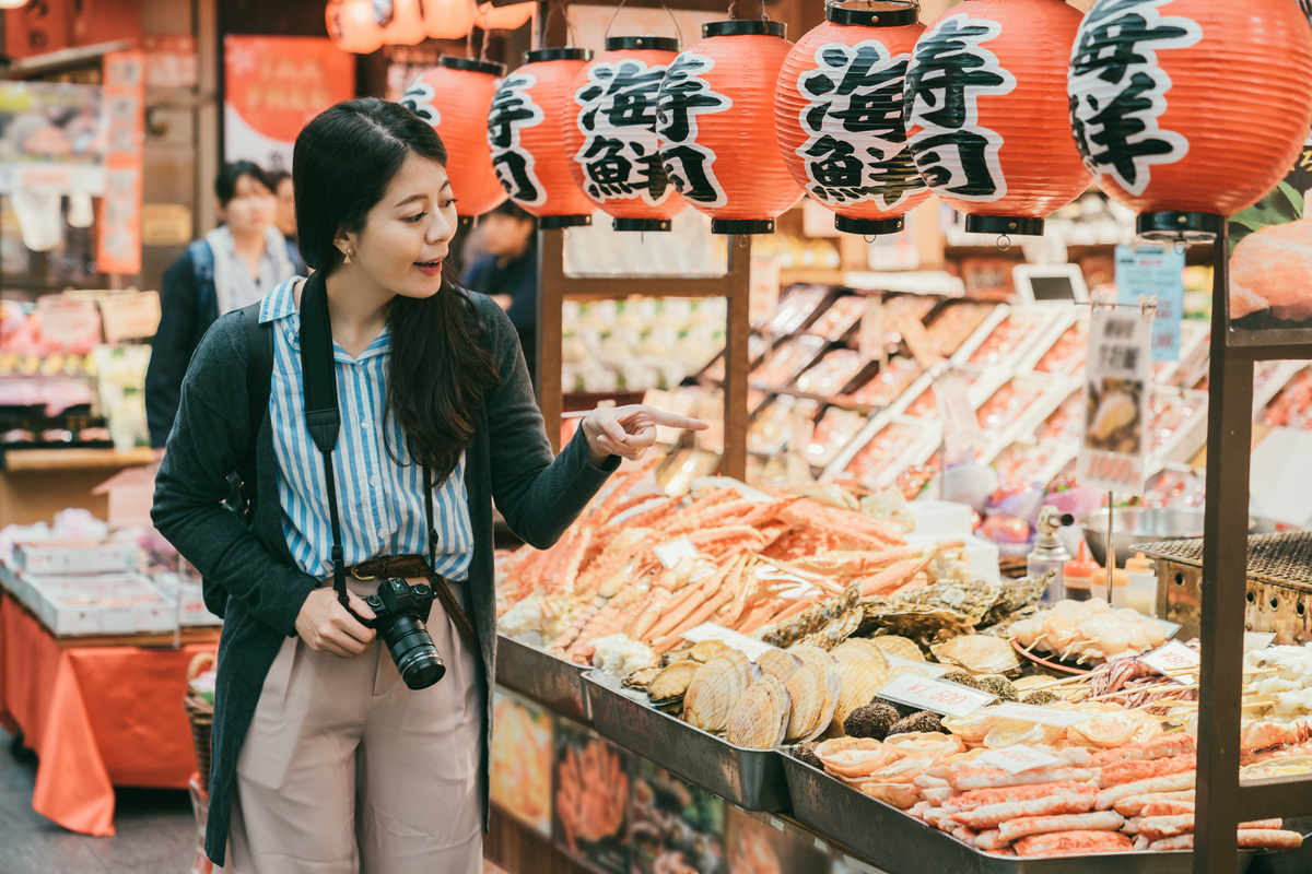 Asian Female Tourist Pointing at Fresh Seafood Displayed in a Sh