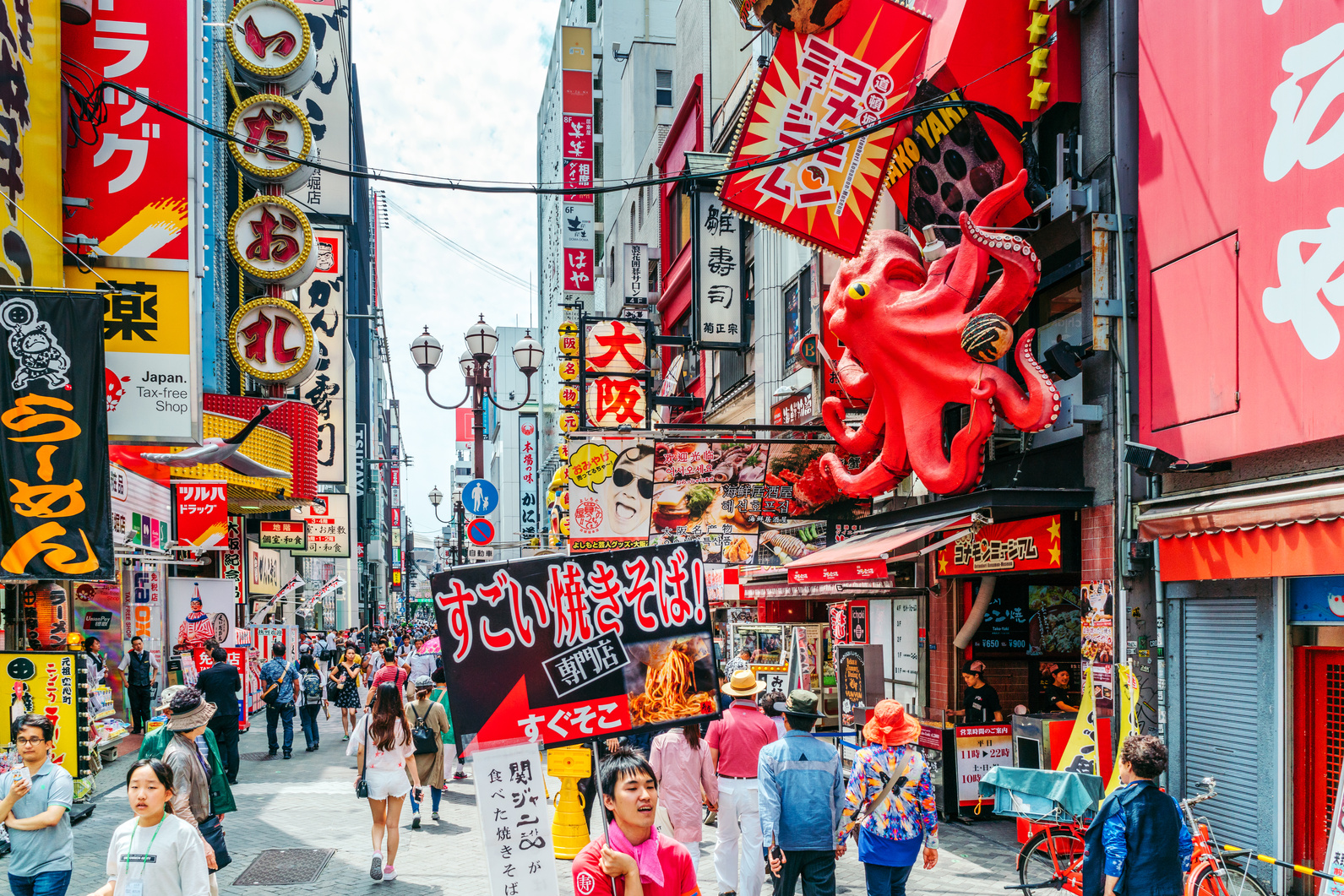 Tourists walking around crowded Osaka Dotonbori entertainment district