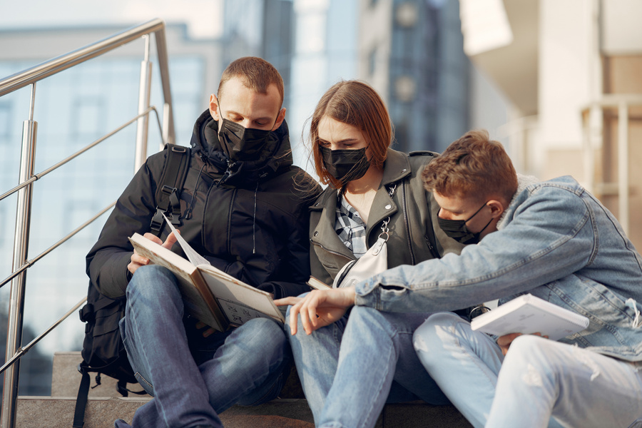 Students in face masks reading books during COVID 19